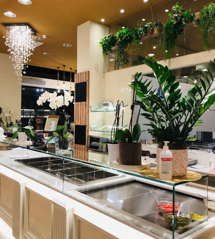 Il banco della gastronomia con orchidee e piante